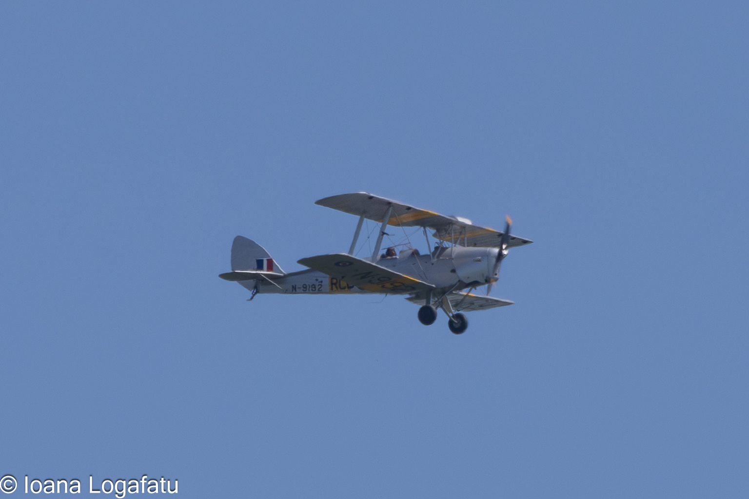 Vintage aircraft gliding through a clear blue sky